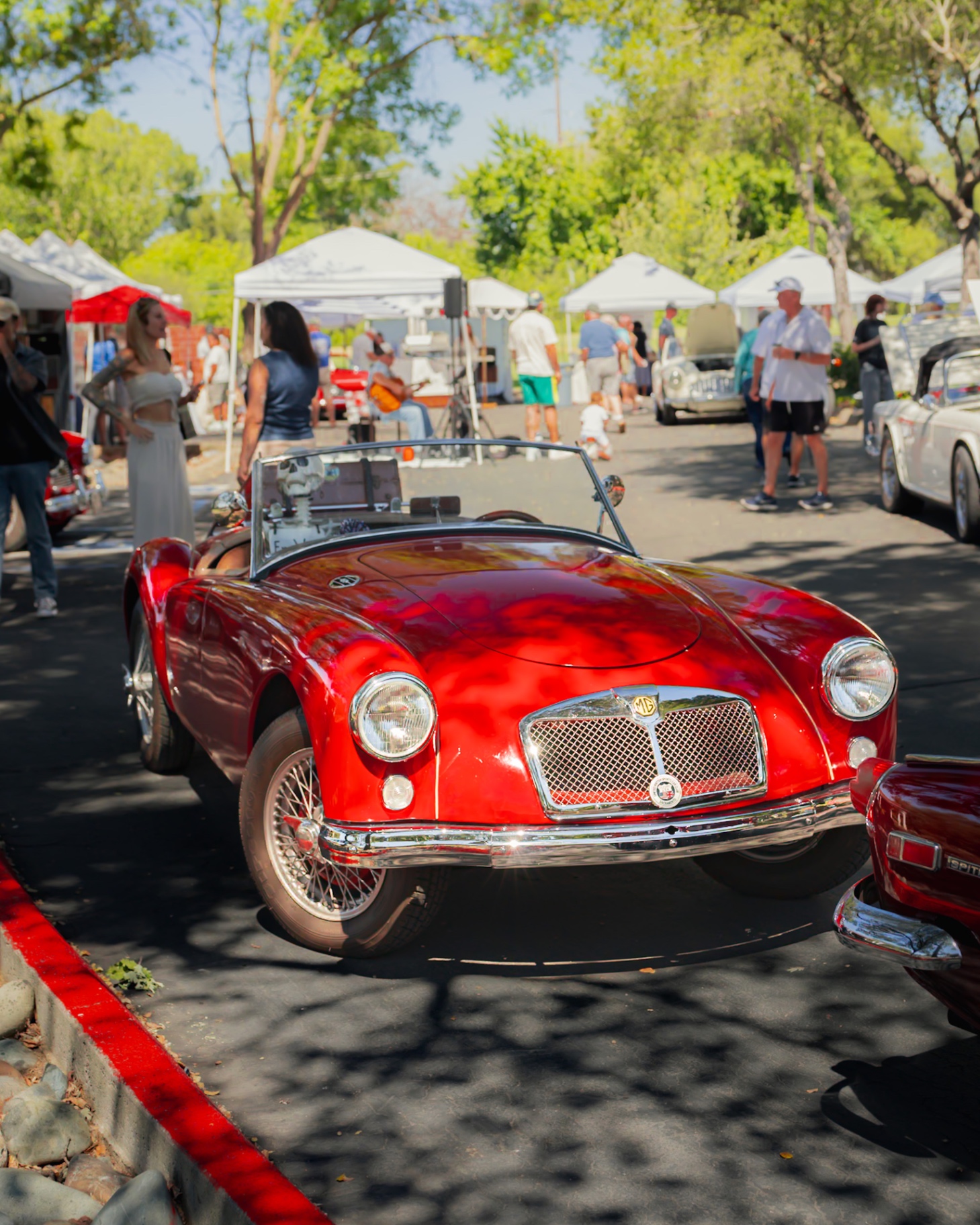 Red MGA roadster parked at the market