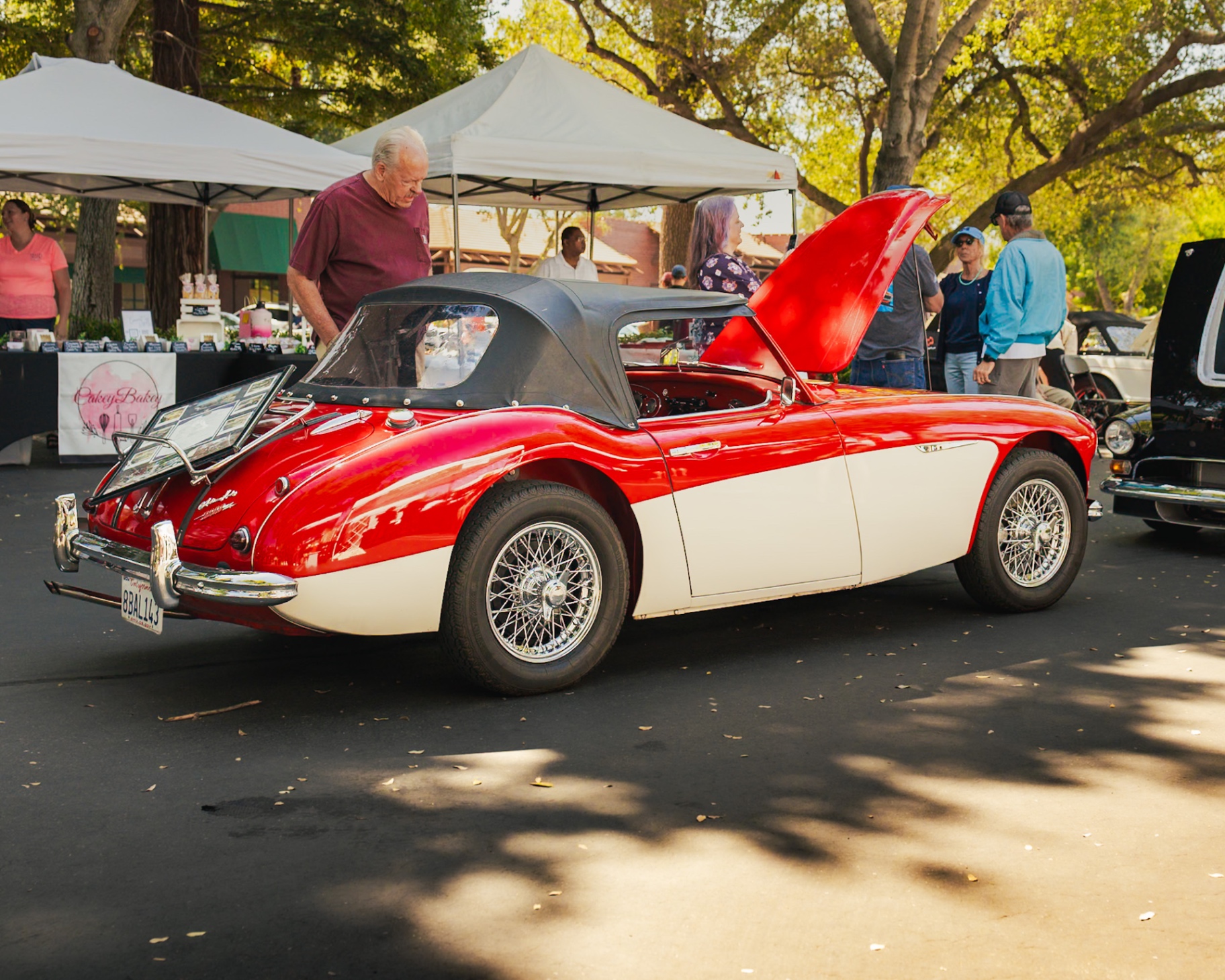 Red and white Austin-Healey convertible with soft top up