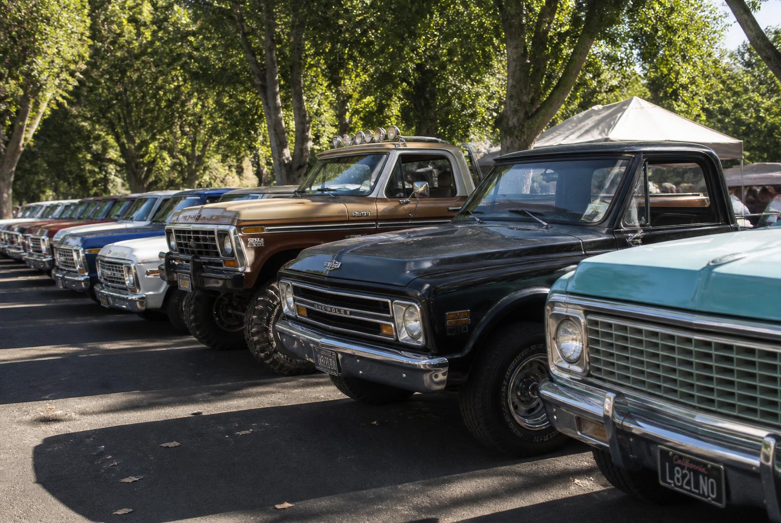 Row of classic trucks lined up at an outdoor car show